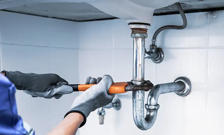 Plumber fixing bathroom sink.